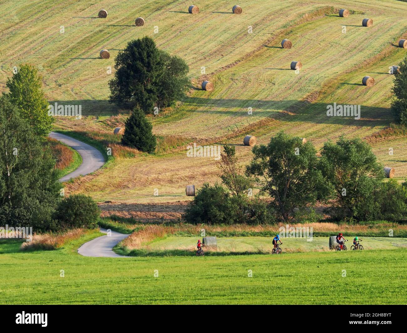 Group of riders riding bicycles trought a rural landscape, Czech republic Stock Photo