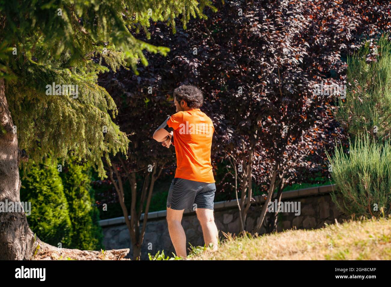 Ankara, Turkey - September 02, 2021: Young man running in the park in a sunny morning while listening to the music with wireless headphones in Dikmen Stock Photo