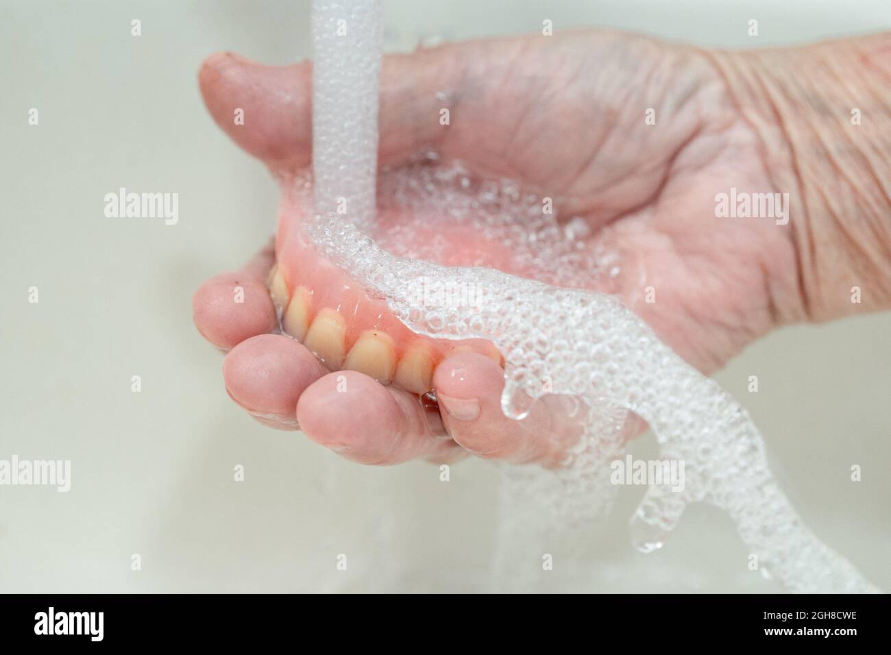 Asian senior or elderly old woman patient holding partial denture of