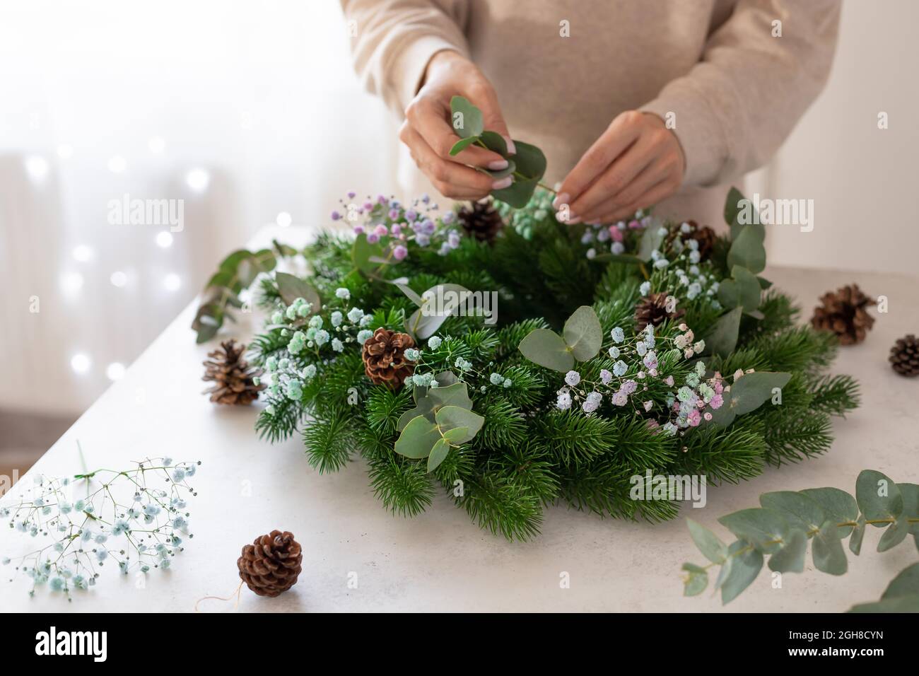 person hands making Christmas wreath. home decoration Stock Photo