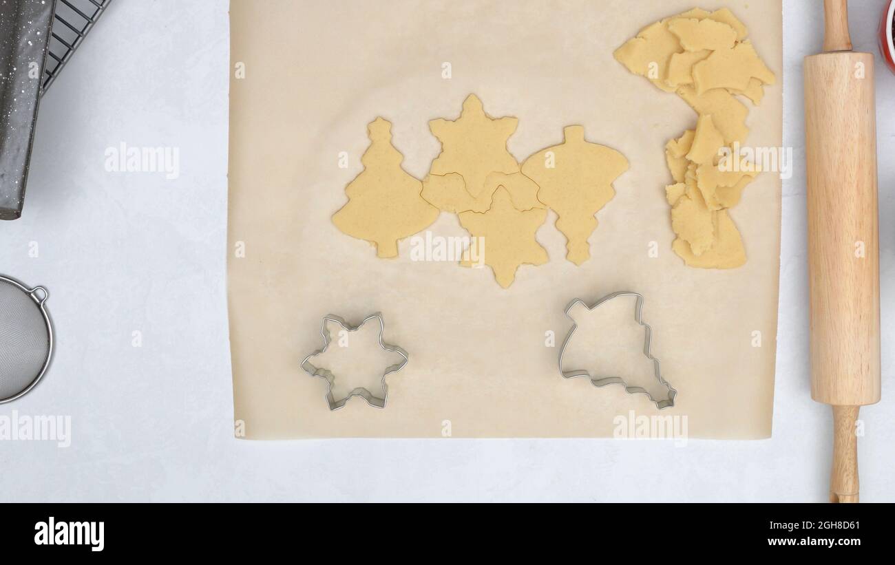 Christmas shortbread cookies with raspberry jam recipe. Chef using cookie cutters to stamp Christmas cookies, pine tree cutter and star cutter Stock Photo