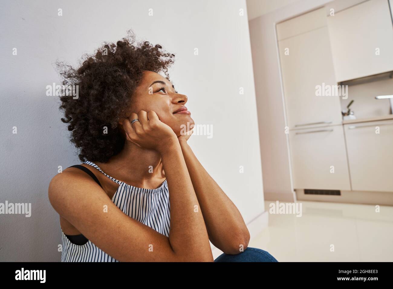 Smiling contented lady daydreaming on the floor Stock Photo