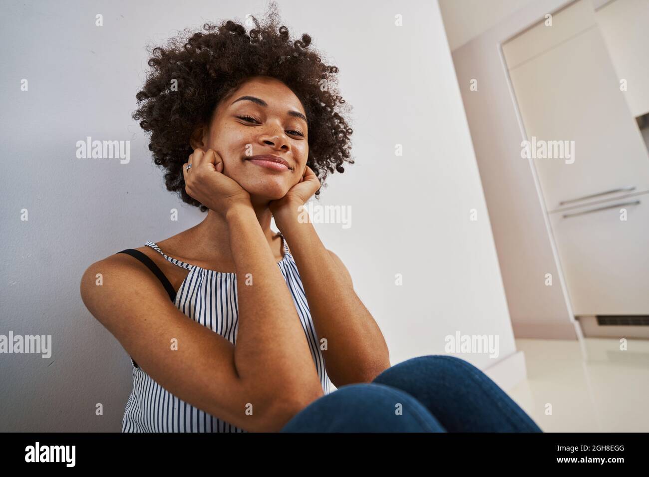 Contented tranquil woman seated on the floor Stock Photo