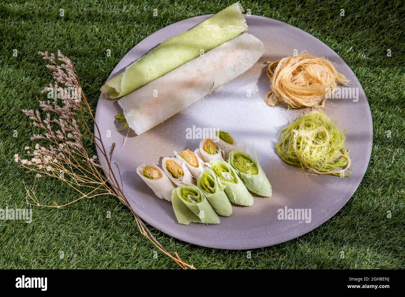 Roti Sai Mai is name of Thai cotton candy wrapped with pastry dough serving with on a white plate. The silk threads roti is one of the favourite Thai Stock Photo