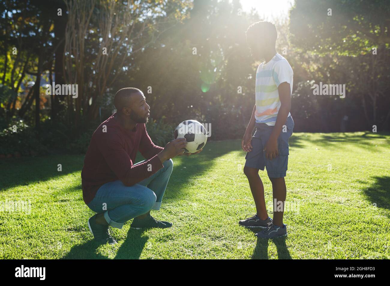 African american father with son having fun and playing with football ...