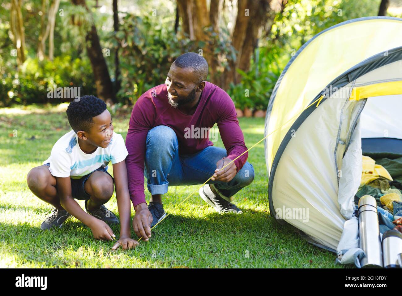 African american father with son having fun pitching tent in garden Stock Photo