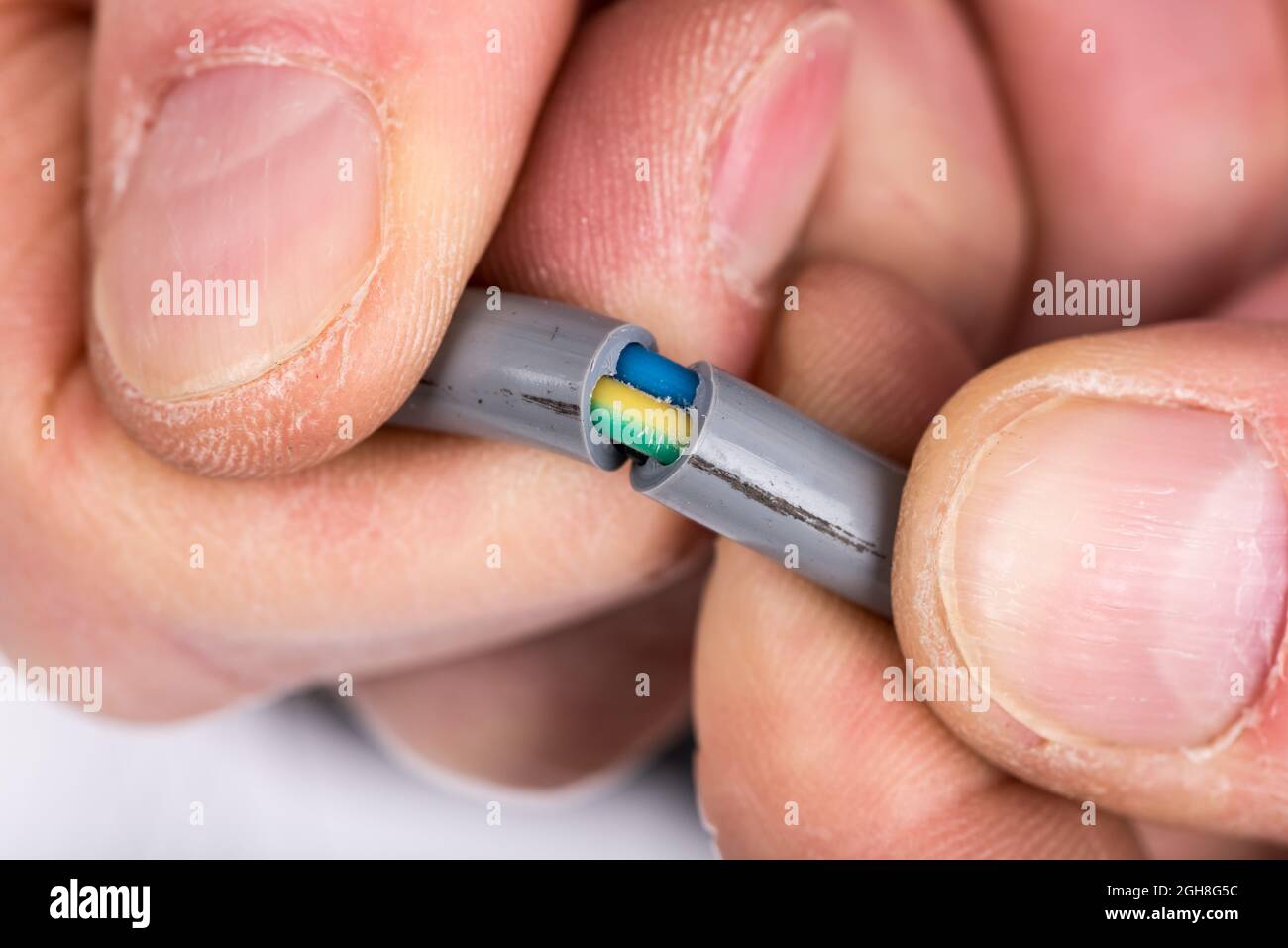 Hand removing the insulation of a power cable Stock Photo Alamy
