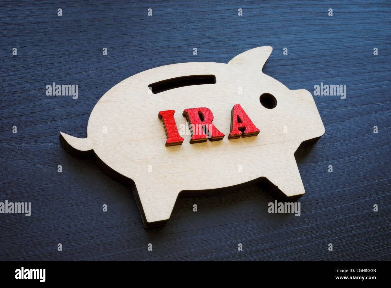 Wooden piggy bank and IRA individual retirement account abbreviation. Stock Photo