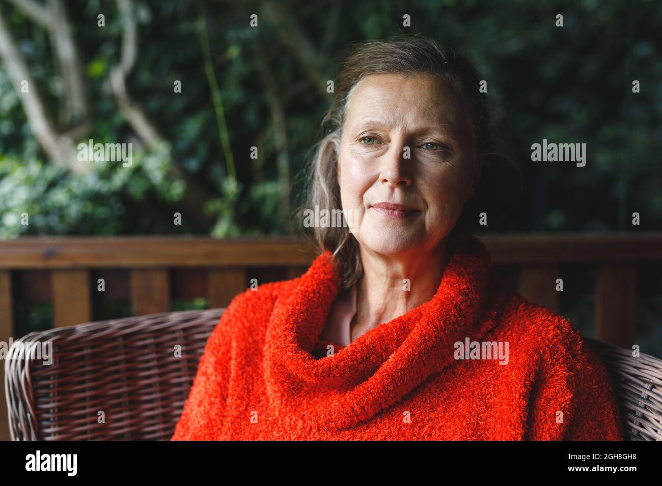 Happy senior caucasian woman sitting on chair in garden Stock Photo