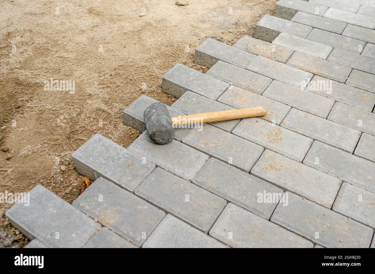 Hammer for sealing the pavement on the newly laid pavement. process of