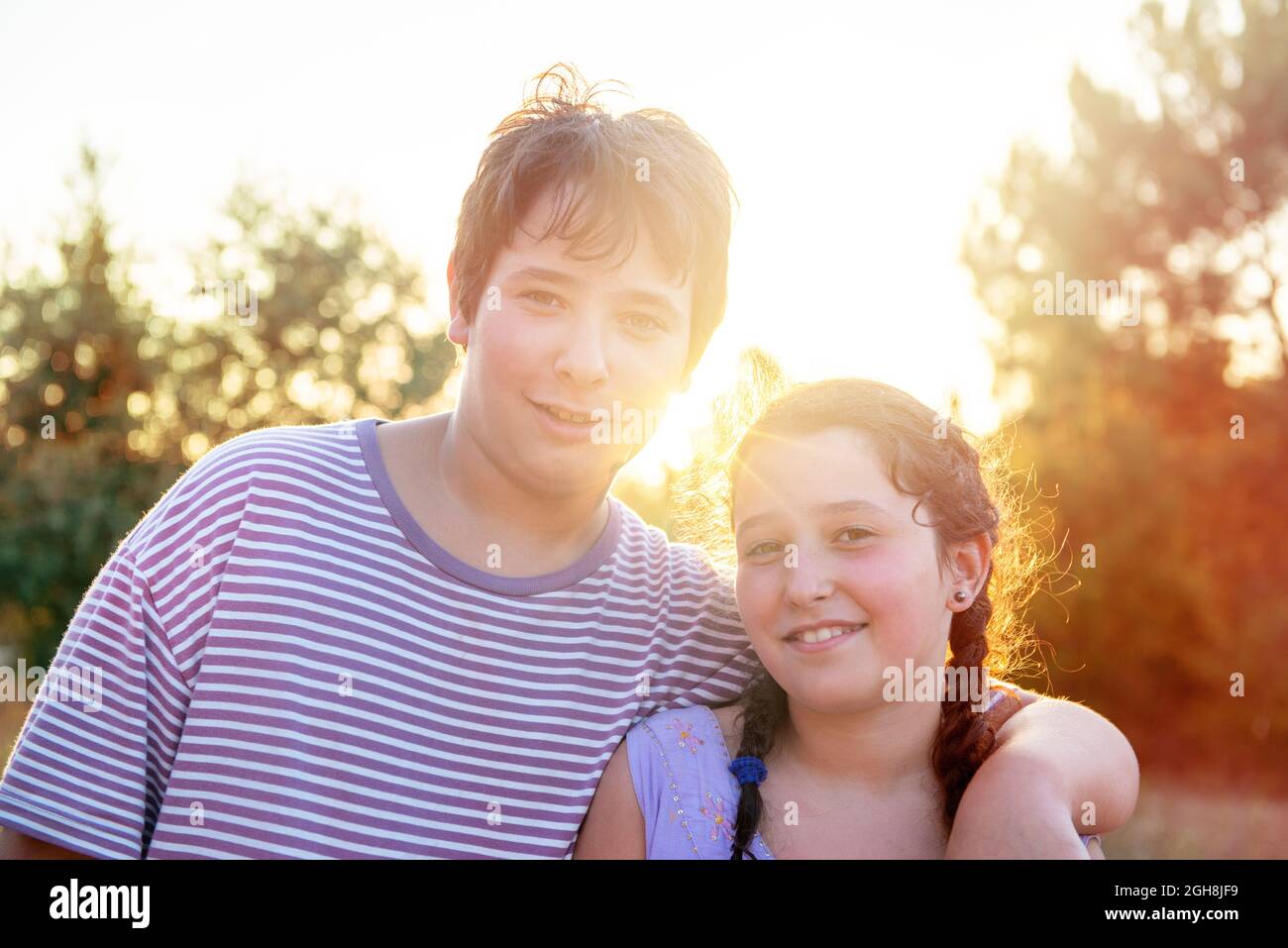 Kid’s couple posing outdoors at sunset Stock Photo