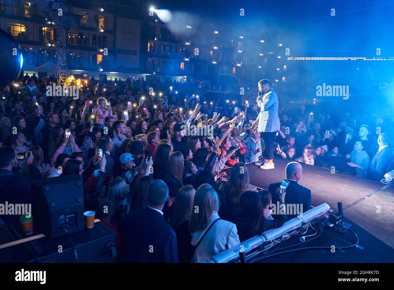 Kiev, Ukraine September 5, 2021: Crowd of spectators at concert in front of stage with flashlights on smartphones. Holding lights of mobile phones. Stock Photo