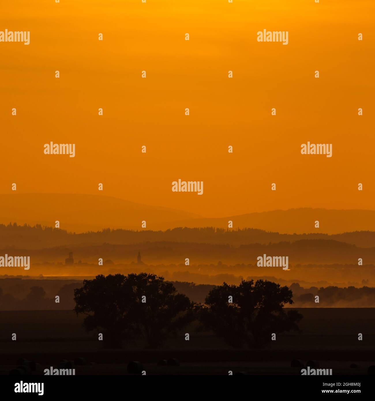 Orange sunset over the fields. Good lighting conditions, distant planes visible Stock Photo