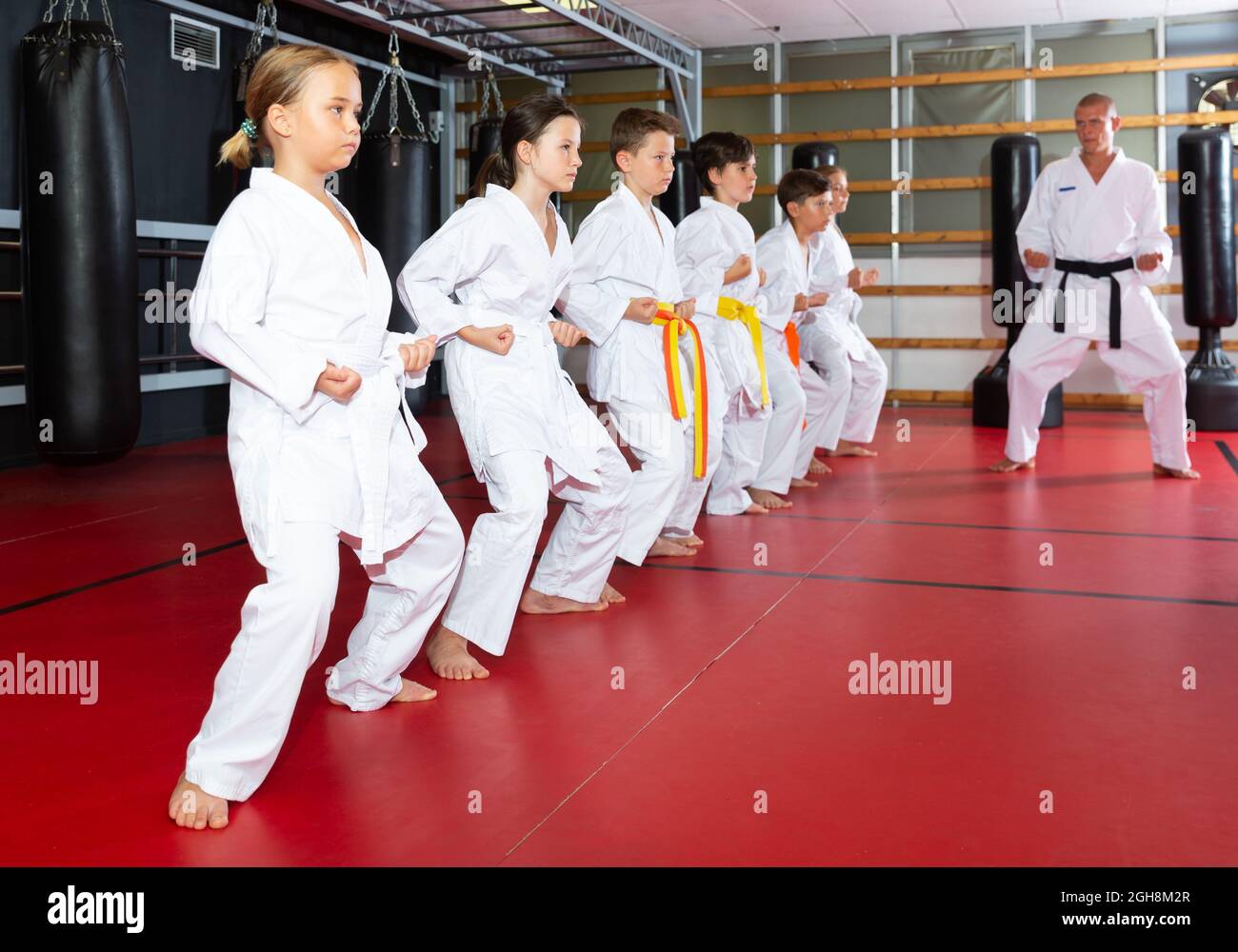 Kids in kimonos practicing effective karate techniques in group workout