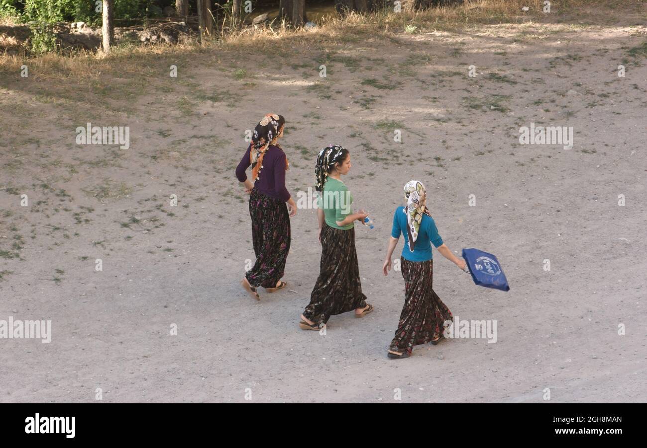 tradition and culture of rural turkey three young women walking on a dirt road of Anatolia dressing traditional clothes Stock Photo