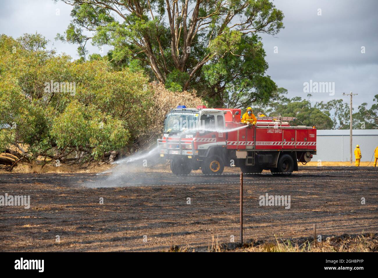 A fire appliance putting out a grass fire, Langley Barfold, Victoria, Australia. Stock Photo