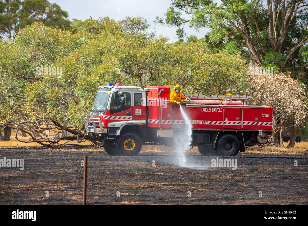 A fire appliance putting out a grass fire, Langley Barfold, Victoria, Australia. Stock Photo