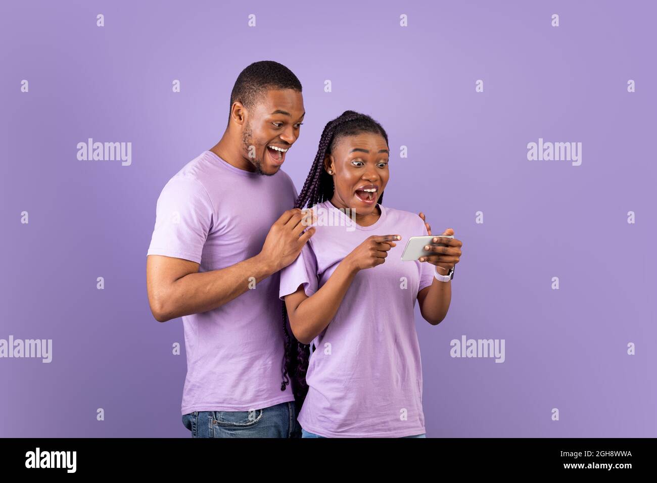 Portrait of surprised black couple using smartphone Stock Photo