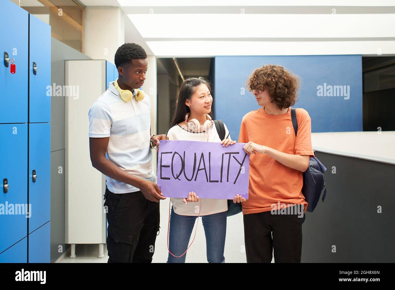 Group of students of different ethnicities carrying a banner at school