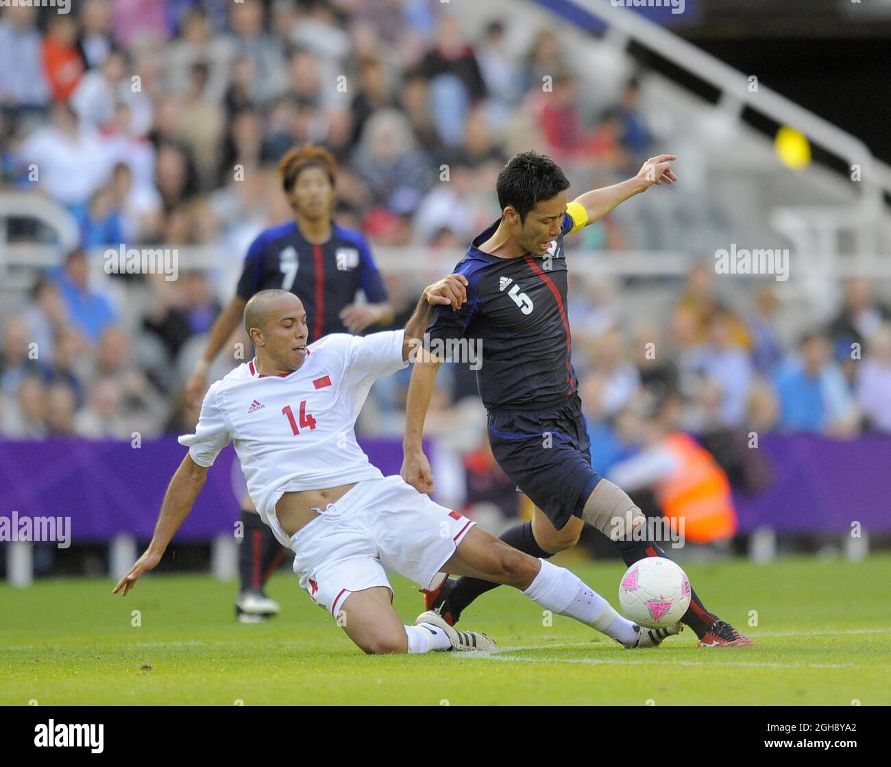 Morocco's Houssine Kharja (L) tackles Japan's Maya Yoshida during the London Olympic 2012 Group D men's match between Japan v Morocco at the St. James' Park, Newcastle upon Tyne on the 29th July 2012. Stock Photo