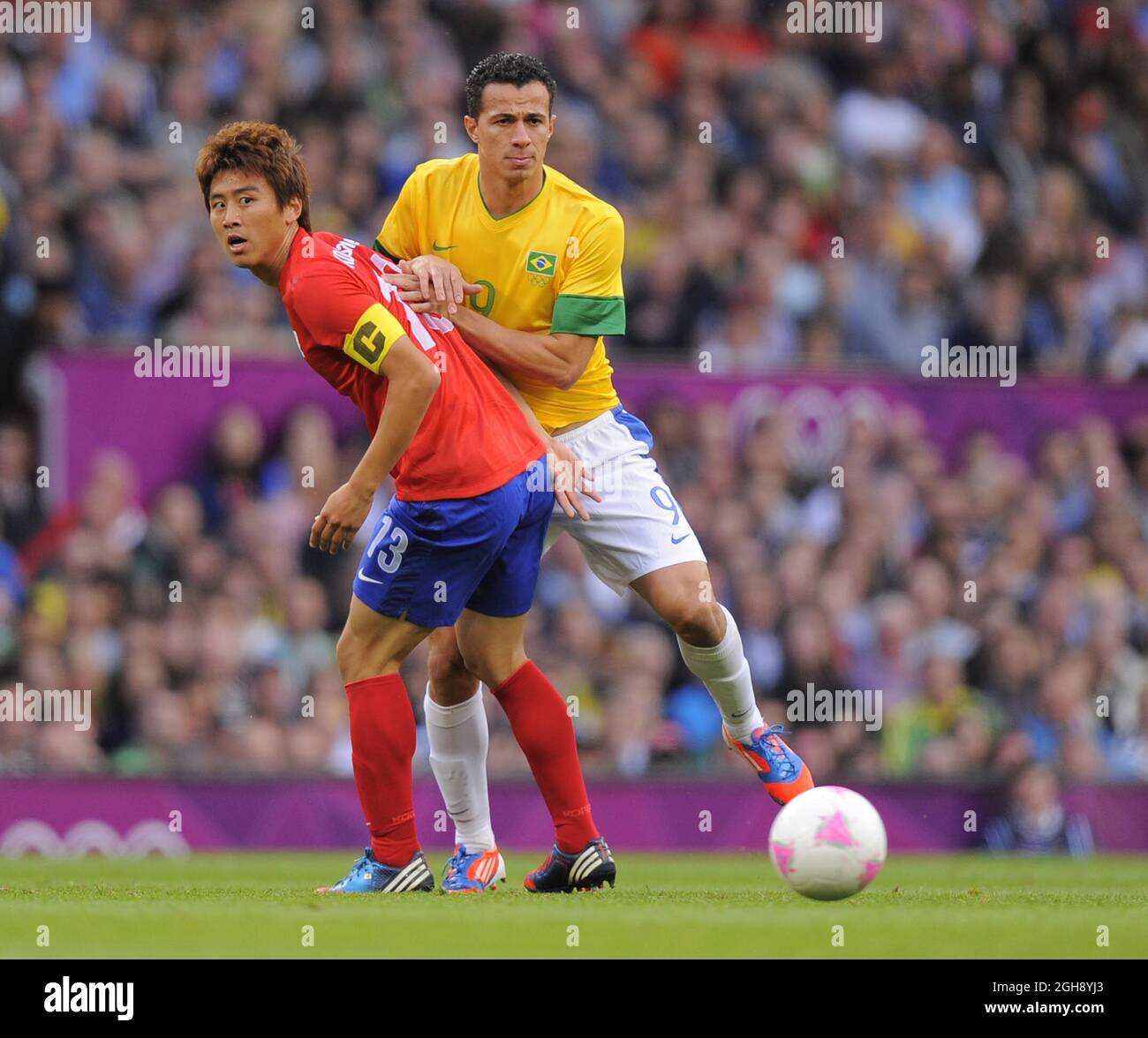 South Korea's Koo Ja-cheol tussles with Brazil's Leandro Damiao.South Korea v Brazil Olympic 2012 semi-final men's match at Old Trafford, Manchester United Kingdom on August 7, 2012. Stock Photo