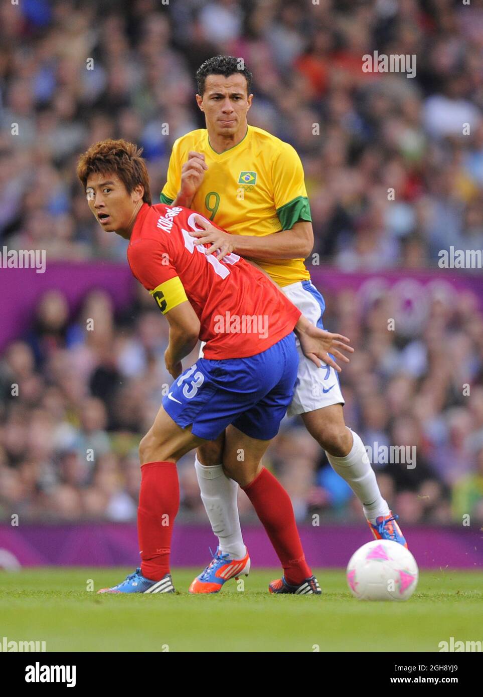 South Korea's Koo Ja-cheol tussles with Brazil's Leandro Damiao.South Korea v Brazil Olympic 2012 semi-final men's match at Old Trafford, Manchester United Kingdom on August 7, 2012. Stock Photo