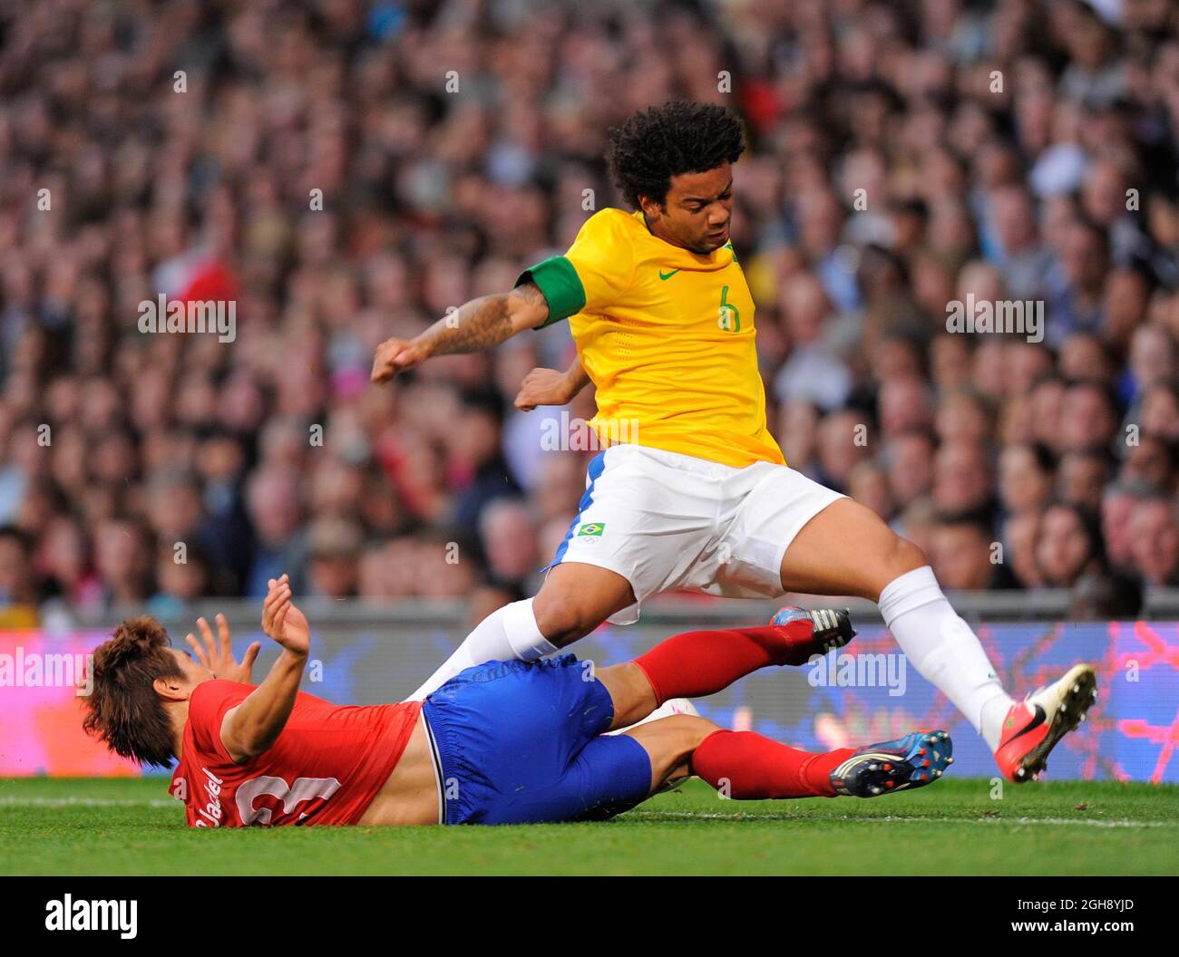 Brazil's Marcelo tackled by South Korea's Koo Ja-cheol.South Korea v Brazil Olympic 2012 semi-final men's match at Old Trafford, Manchester United Kingdom on August 7, 2012. Stock Photo