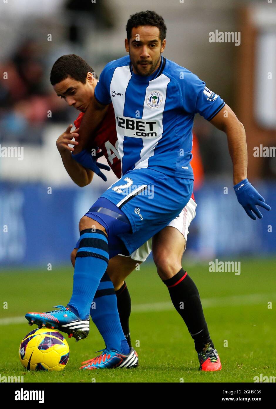Jean Beausejour of Wigan Athletic in action with Rafael of Manchester United during the Barclays Premier League between Wigan Athletic and Manchester United at the DW Stadium in Wigan, England on January 01, 2013. Stock Photo