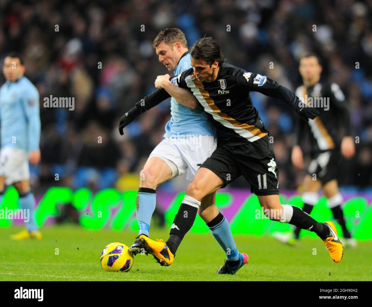 Gareth Barry of Manchester City tussles with Bryan Ruiz of Fulham during the Barclays Premier League soccer match between Manchester City and Fulham at Etihad Stadium in Manchester, United Kingdom on January 19, 2013. Picture Simon Bellis Stock Photo