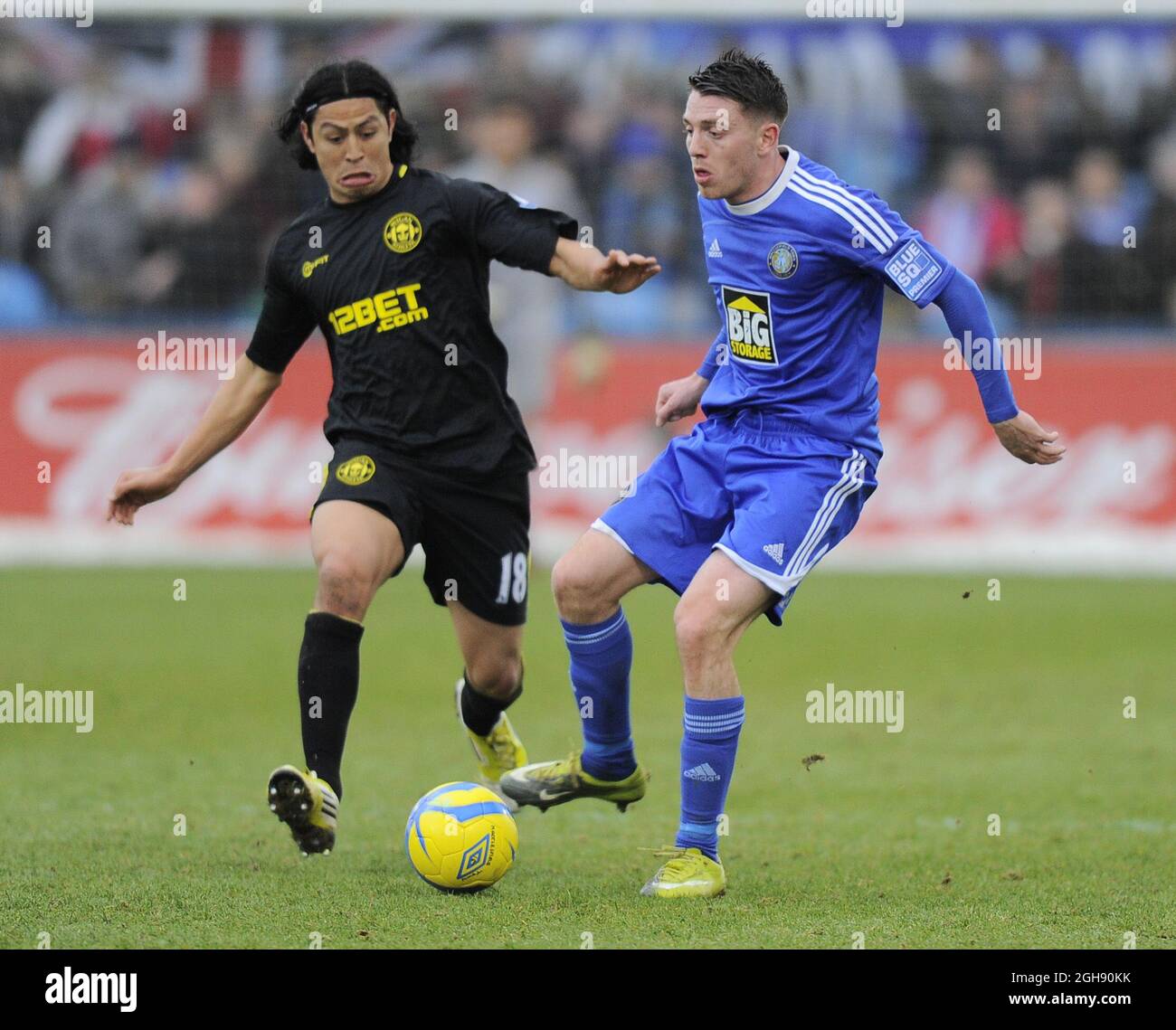 Roger Espinoza of Wigan Athletic tussles with Sam Wedgbury of Macclesfield Town during the FA Cup 4th Round match between Macclesfield Town and Wigan Athletic at the Moss Rose Stadium in Macclesfield, United Kingdom on 26th January 2013. Stock Photo