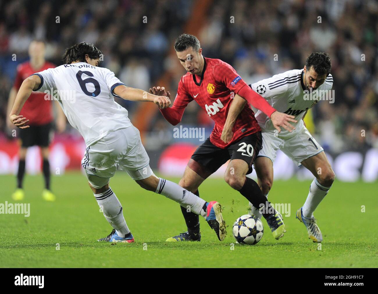 Robin van Persie of Manchester United tussled with Sami Khedira of Real Madrid and Alvaro Arbeloa of Real Madrid during the UEFA Champions League First Knockout Round of 16, 1st leg match between Real Madrid and Manchester Utd at Santiago Bernabeu Stadium in Madrid, Spain on 13th February 2013 Stock Photo