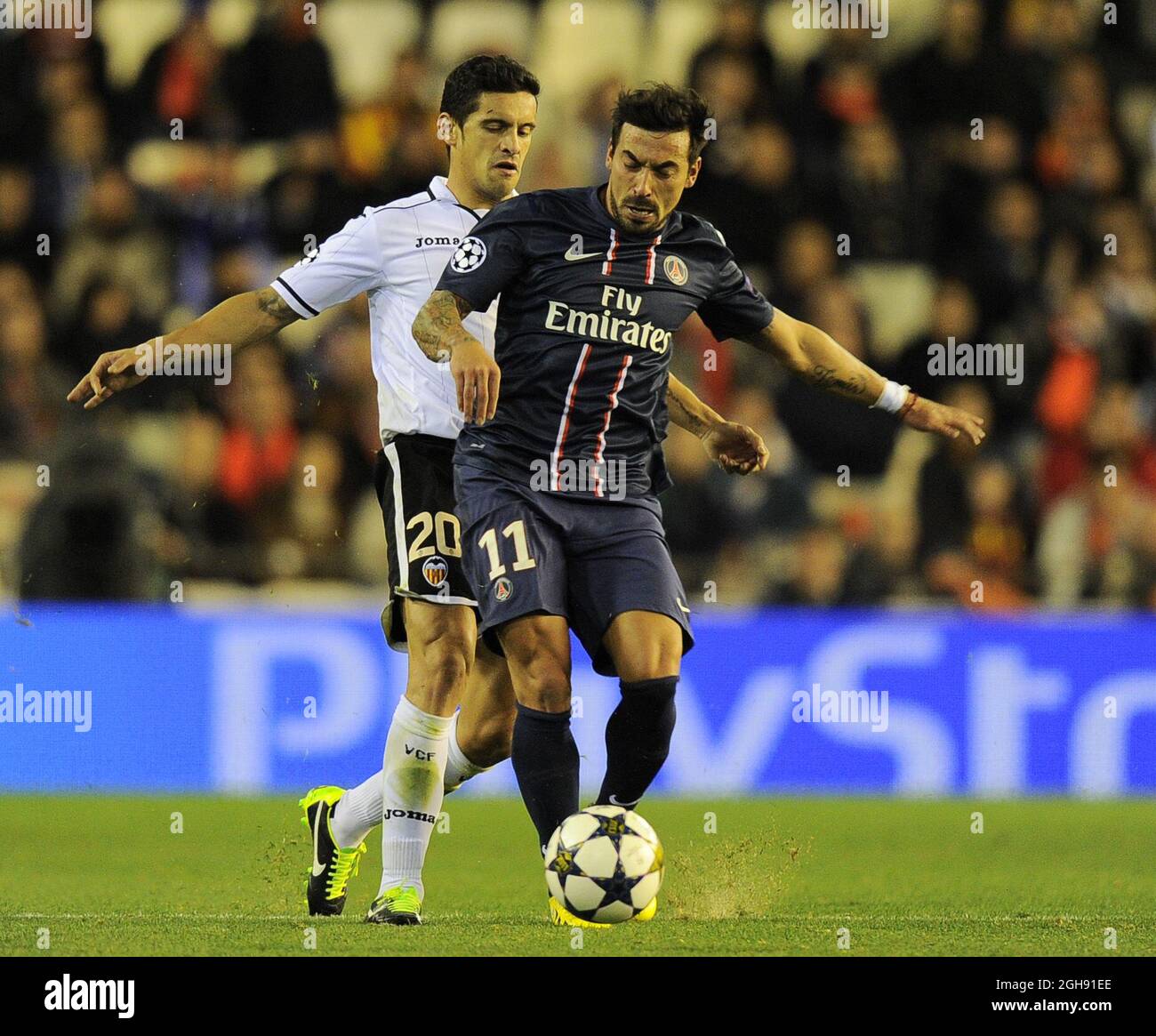 Ezequiel Lavezzi of Paris Saint Germain tussles with Ricardo Costa of Valencia during the UEFA Champions League First Knockout Round of 16, first leg soccer match between Valencia and Paris Saint-Germain at the Mestalla Stadium in Valencia, Spain on February 12, 2013. CSMLandov Stock Photo