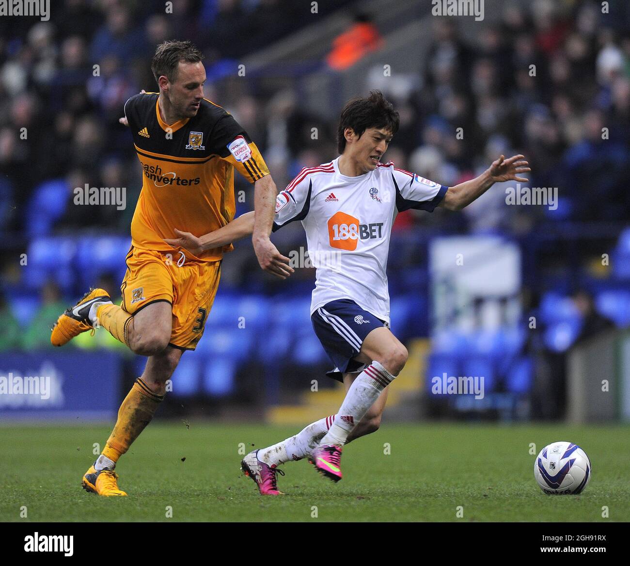 David Meyler of Hull City tussles with Lee Chung-Yong of Bolton Wanderers during the npower Football League Championship match between Bolton Wanderers and Hull City at Reebok Stadium in Bolton, UK on Feb. 23, 2013. Stock Photo