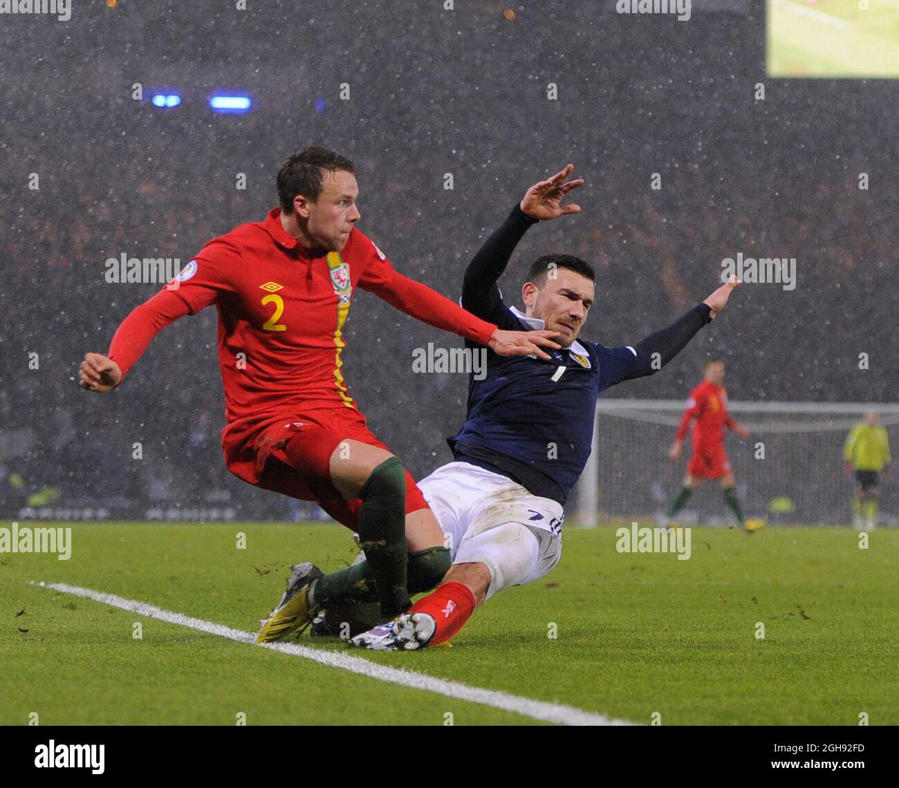 Robert Snodgrass of Scotland fouls Chris Gunter of Wales to be sent off and concede a penalty during the FIFA 2014 World Cup Group A qualifying match between Scotland and Wales at Hampden Park in Glasgow, Scotland on on March 22, 2013. Stock Photo
