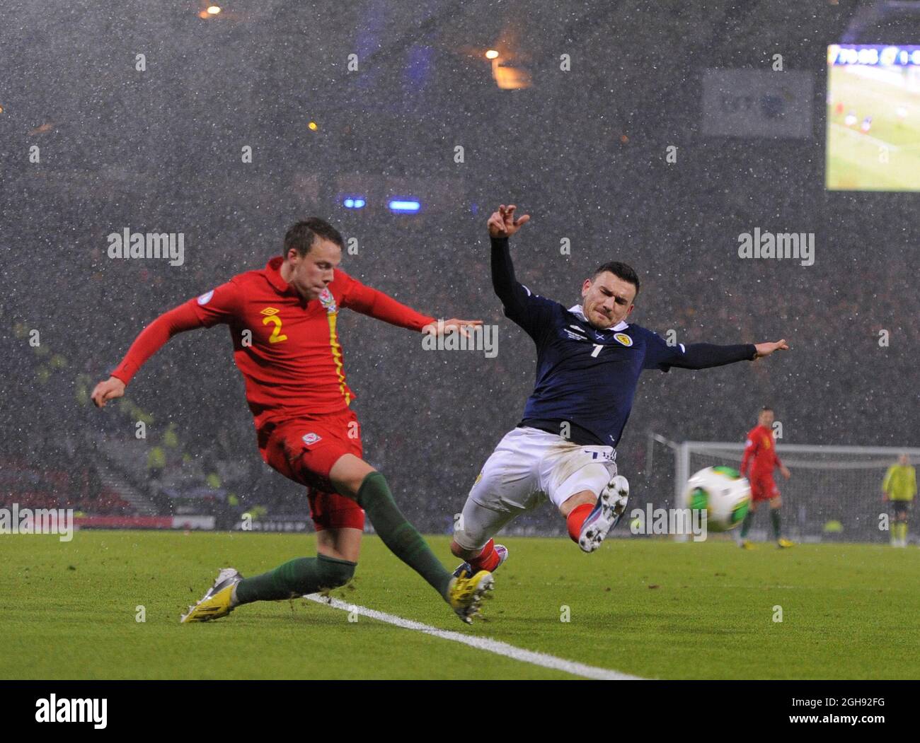 Robert Snodgrass of Scotland launches himself into Chris Gunter of Wales which led to the red card for Snodgrass during the FIFA 2014 World Cup Group A qualifying match between Scotland and Wales at Hampden Park in Glasgow, Scotland on on March 22, 2013. Stock Photo
