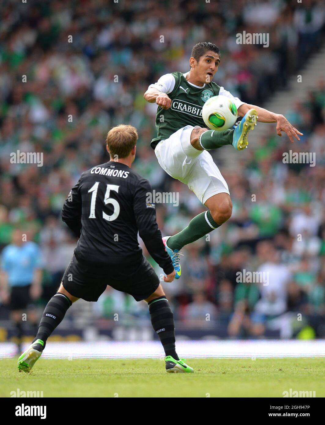 Jorge Claros of Hibernian jumps up and flicks the ball past Kris Commons of Celtic during the William Hill Scottish Cup Final between Hibernian and Celtic at the Hampden Park Stadium in Glasgow, Scotland on May 26, 2013. Picture Simon Bellis Stock Photo
