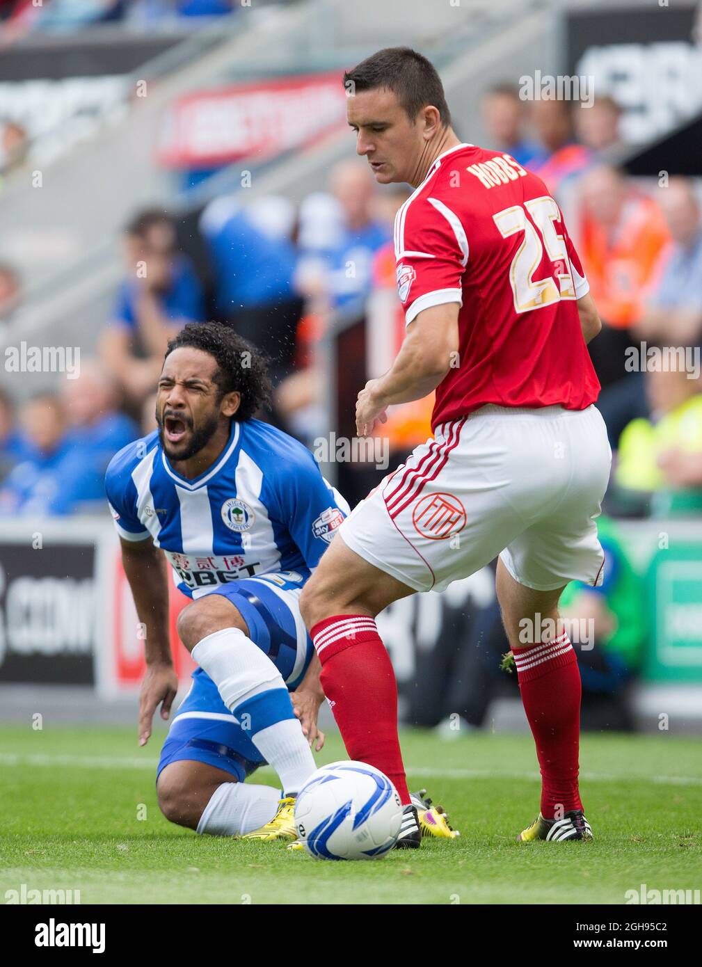 Forest's Jack Hobbs challenges Wigan's Jean Beausejour during the Sky Bet Football League Championship match between Wigan Athletic and Nottingham Forest at the DW Stadium, Wigan on August 31, 2013. Stock Photo
