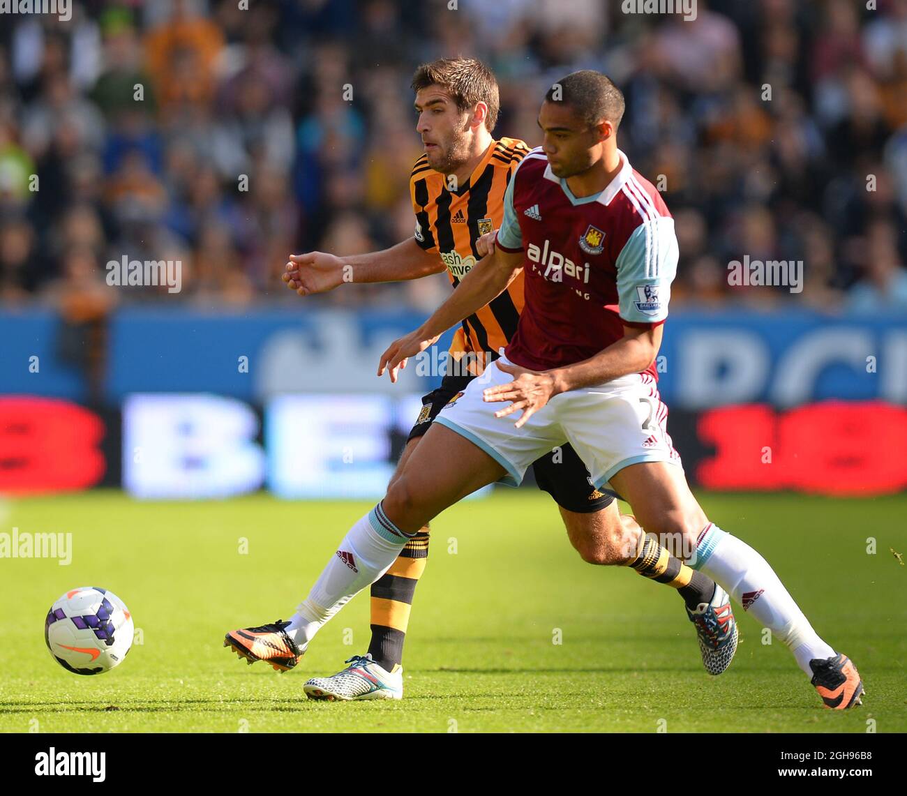 Danny Graham of Hull City tussles with Winston Reid of West Ham United during the Barclays Premier League match between Hull City and West Ham United at the Kingston Communications Stadium in Hull, United Kingdom on September 28, 2013. Stock Photo