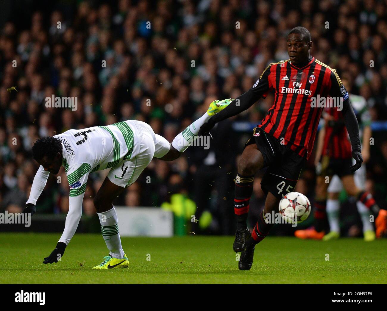 Mario Balotelli of AC Milan challenges Efe Ambrose of Celtic during the UEFA Champions League Group H match between Celtic and AC Milan held at Celtic Park in Glasgow, Scotland on Nov. 26, 2013. Stock Photo