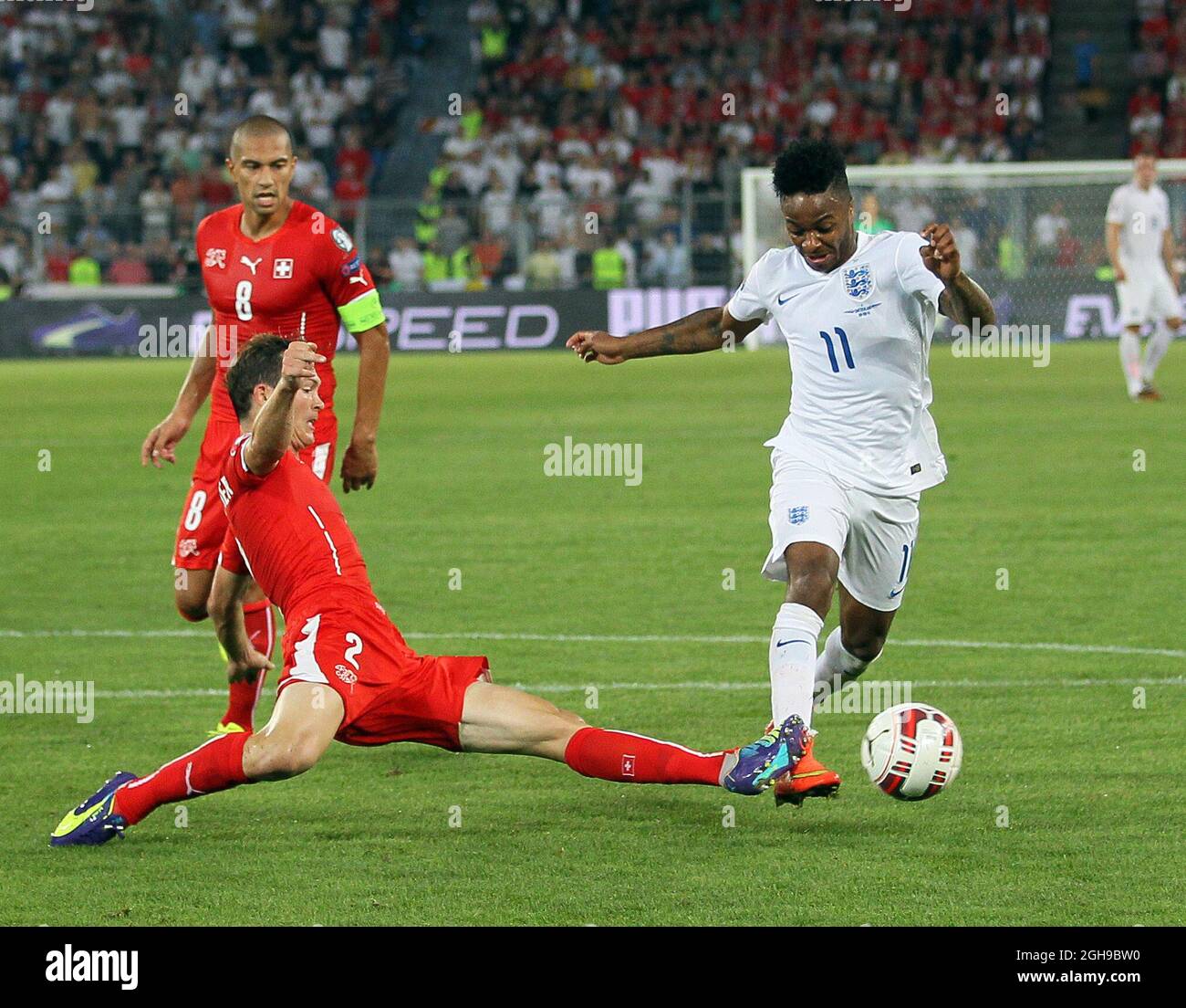 Switzerland's Johan Djourou tussles with England's Raheem Sterling during the UEFA Euro 2016 Qualifying Group E match between Switzerland and England held at the St Jakob Park in Switzerland on September 8, 2014.Picture David Klein/Sportimage. Stock Photo