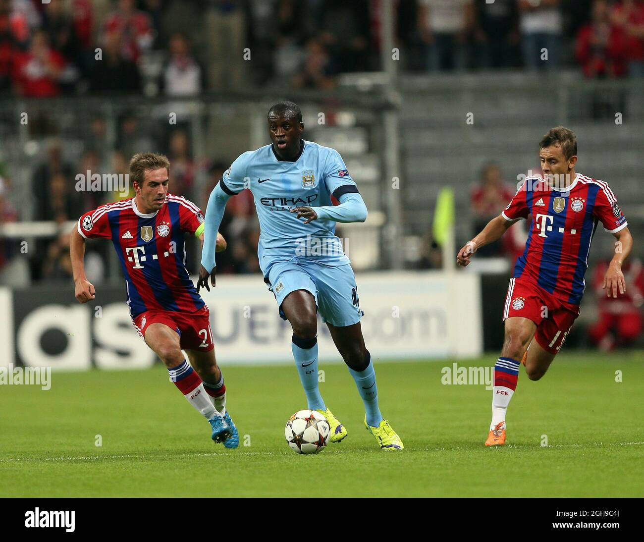 Bayern Munich's Philipp Lahm tries to tackle Manchester City's Yaya Toure during the Champions League Group E match between Bayern Munich and Manchester City held at Allianz Arena in Germany on Sept. 17, 2014 . Stock Photo