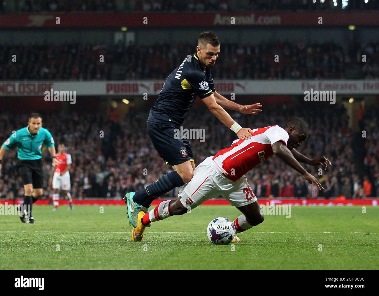 Arsenal's Joel Campbell goes down under the challenge from Southampton's Morgan Schneiderlin but no penalty is given during the Capital One Cup Third Round match at the Emirates Stadium, London on 23, September 2014. Stock Photo