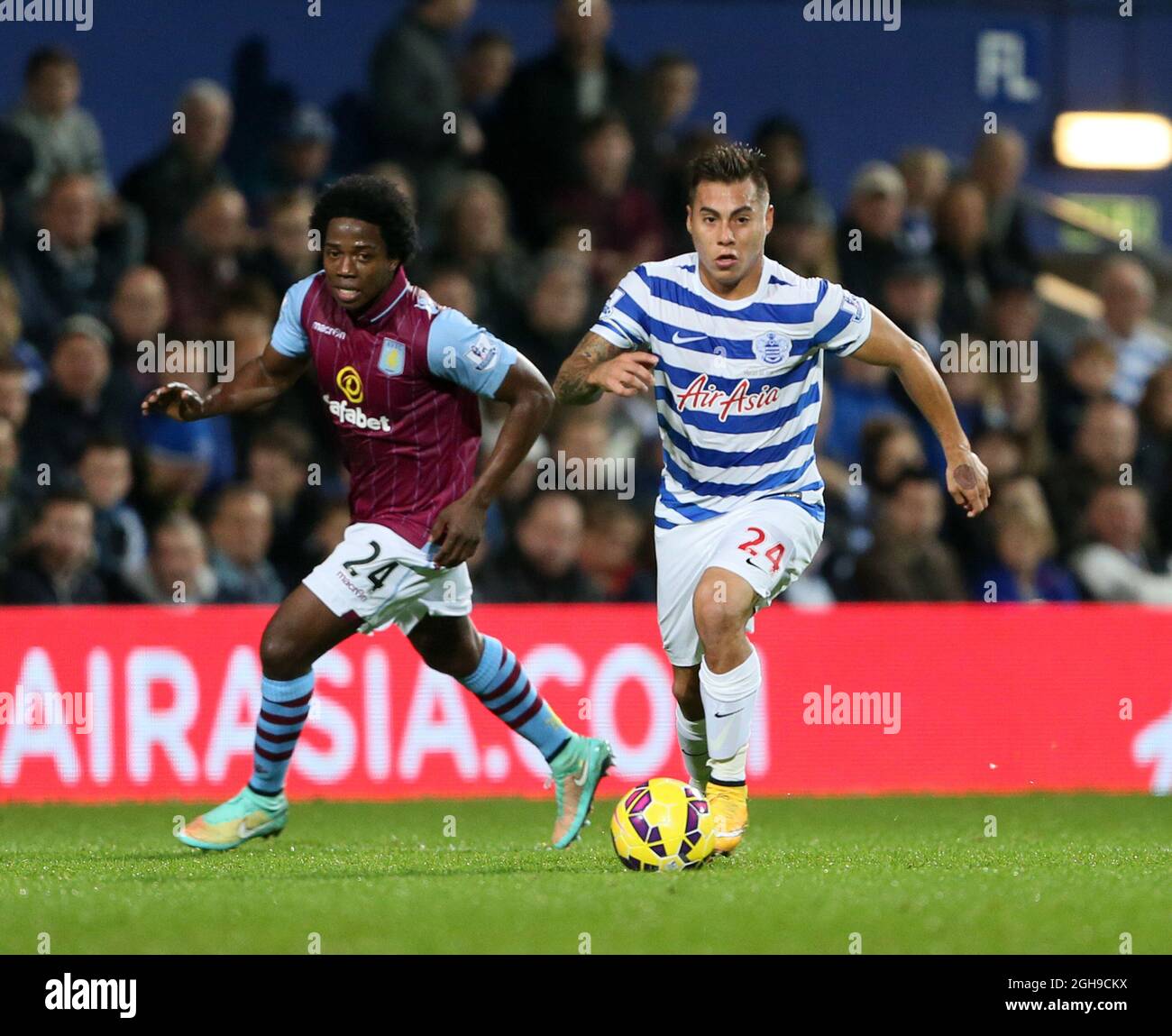 QPR's Eduardo Vargas tussles with Aston Villa's Carlos Sanchez during the Barclays Premier League match between Queens Park Rangers and Aston Villa at the Loftus Road in England on October 27, 2014. Stock Photo