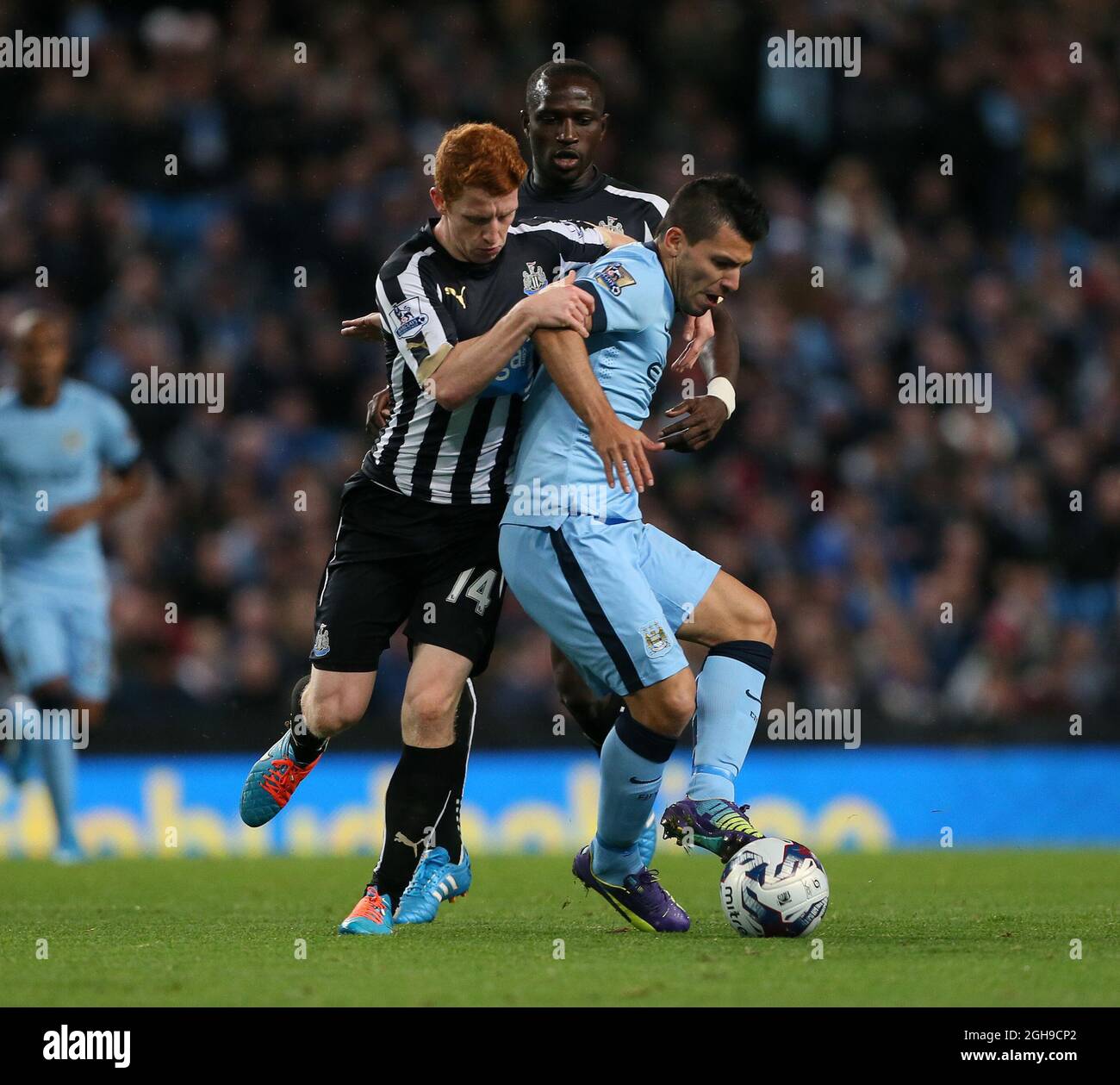 Manchester City's Sergio Aguero tussles with Newcastle's Jack Colback during the Capital One Cup Fourth Round match between Manchester City and Newcastle United at the Etihad Stadium, London on 29, October 2014. Stock Photo