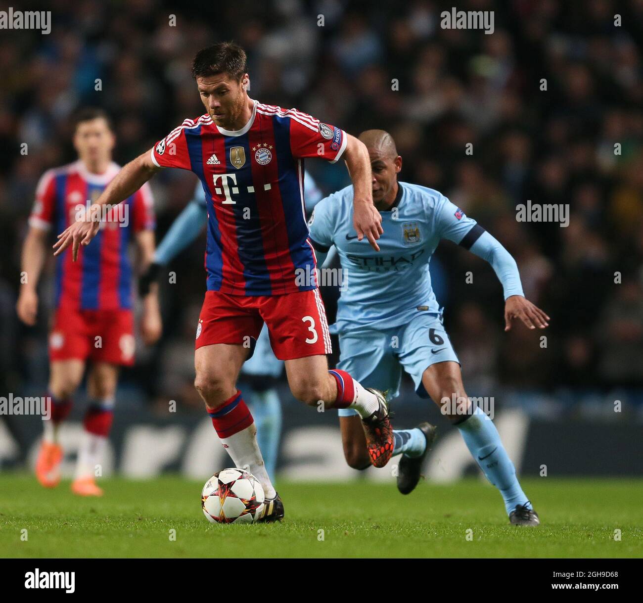 Fernando of Manchester City and Xabi Alonso of Bayern Munich during the Champions League Group E match between Manchester City and Bayern Munich held at Etihad Stadium in England on Nov. 25, 2014. Stock Photo