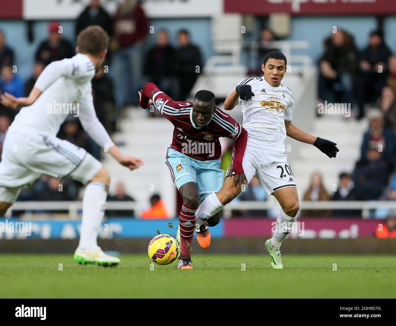 West Ham's Enner Valencia tussles with Swansea's Jefferson Montero during the Barclays Premier League match between West Ham United and Swansea City in Upton Park, London , England on 7th December 2014. Stock Photo