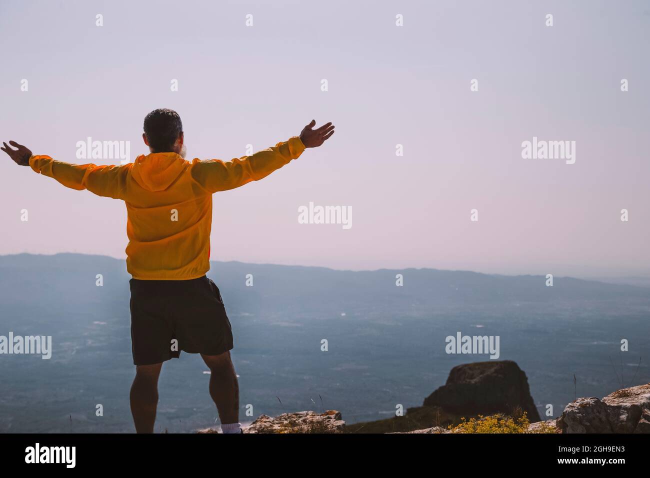 silhouette man raising hands on the mountain in the morning with vintage light Stock Photo