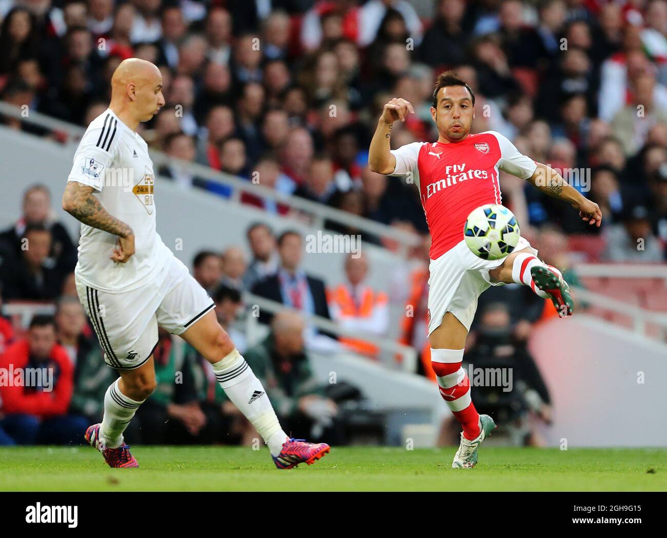 Arsenal's Santi Cazorla tussles with Swansea's Jonjo Shelvey during the Barclays Premier League match between Arsenal and Swansea City at the Emirates Stadium in England on 11th May 2015. Stock Photo