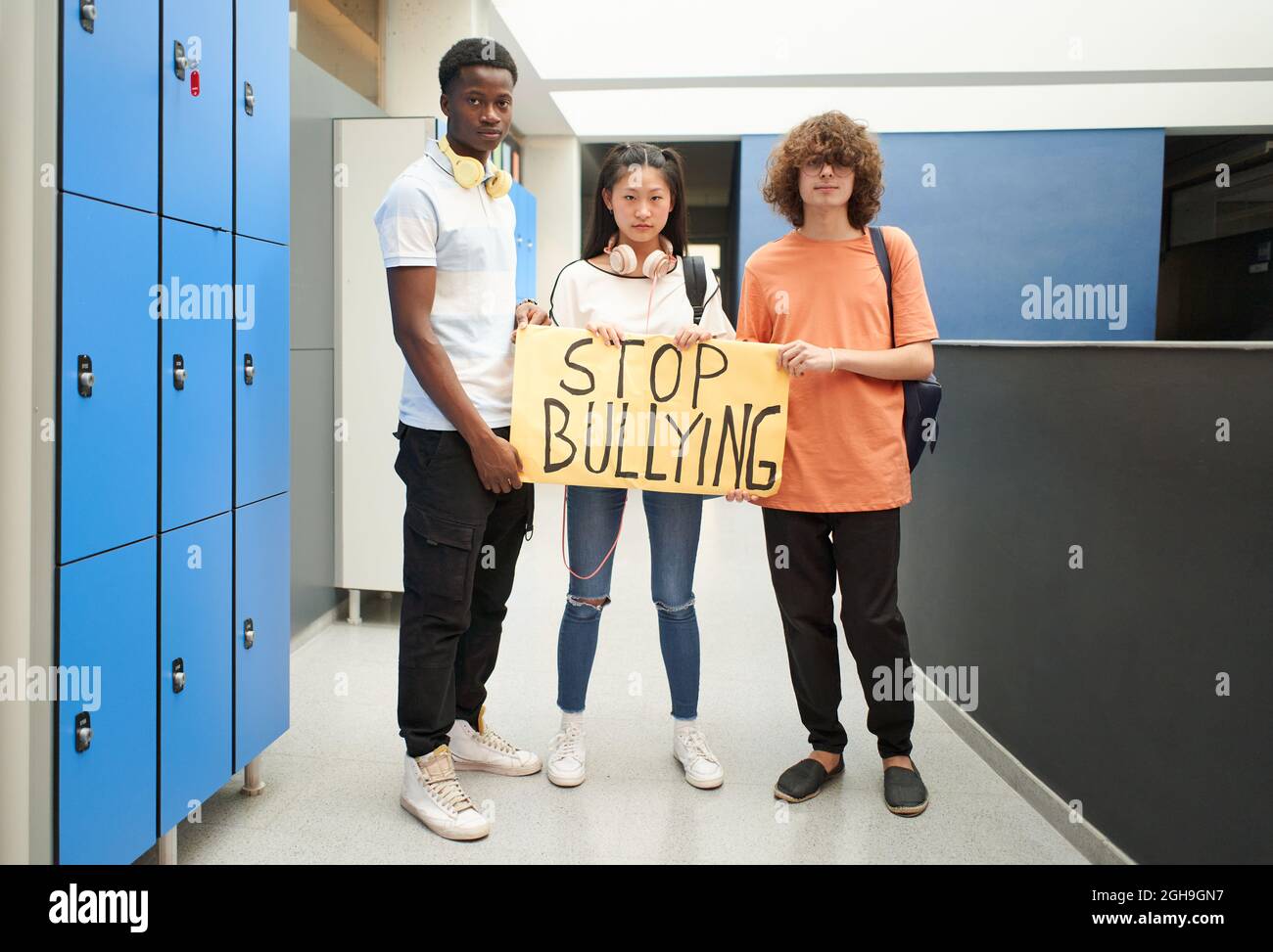 Racially diverse group of students demonstrates against bullying. Older school students looking at the camera as they work for equality. Stock Photo