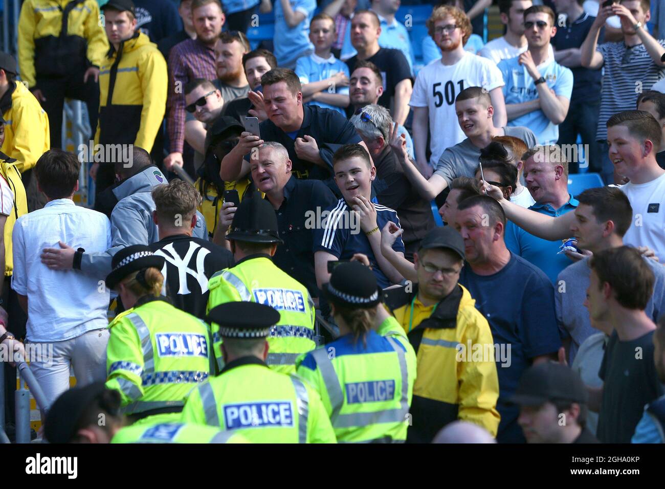 Manchester City fans taunt an Arsenal fan as he is ejected by police for  fighting during the Barclays Premier League match at the Etihad Stadium.  Photo credit should read: Philip Oldham/Sportimage via